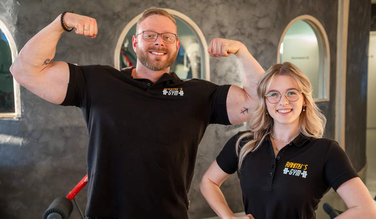 Marvin und Julia Rahm in schwarzen Polo-Shirts mit Rahmy's-Gym-Logo im Studio